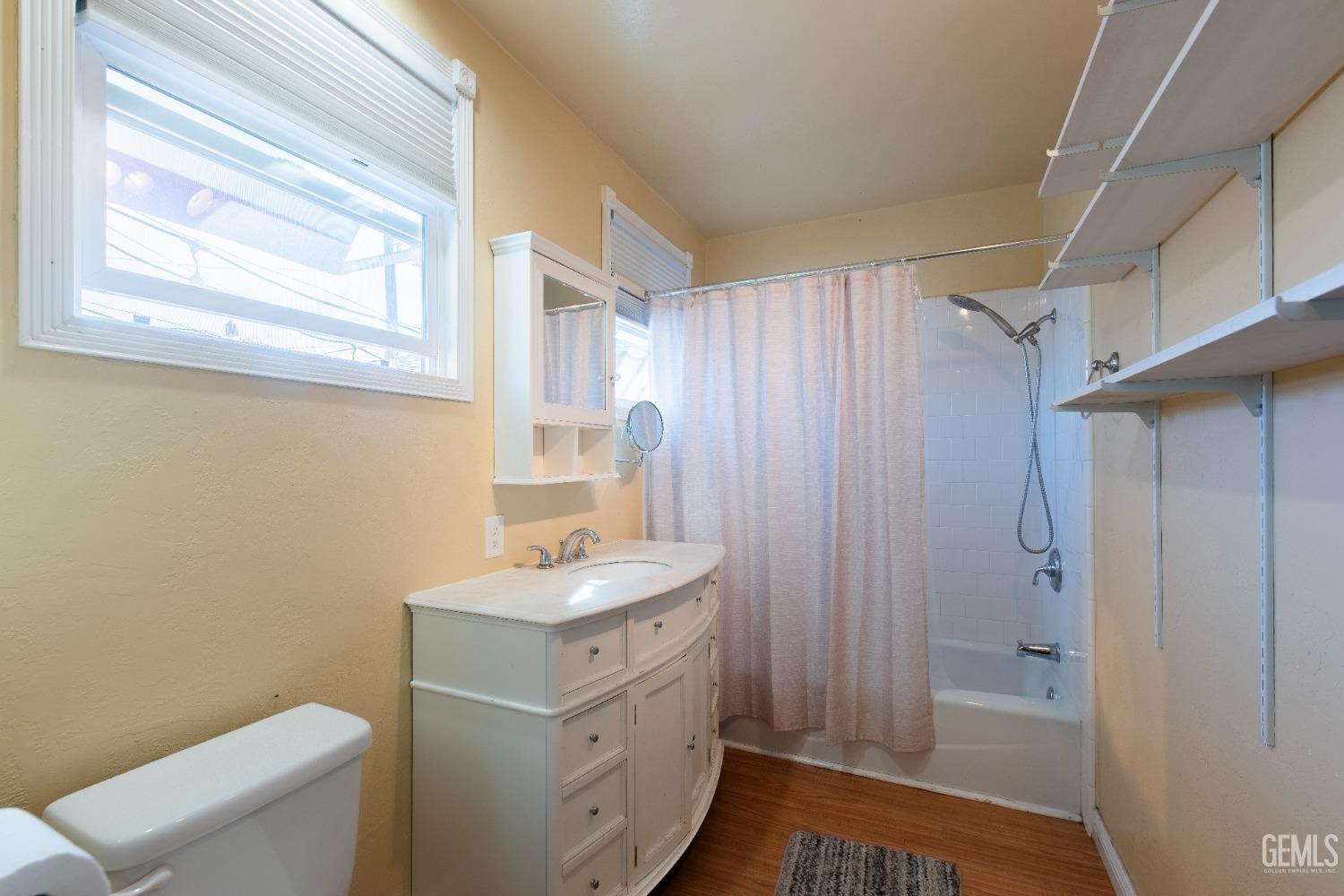 Undisclosed Address Bakersfield, CA 93305 - Photo 17 of 27 a bathroom with a granite countertop sink toilet a shower and a window