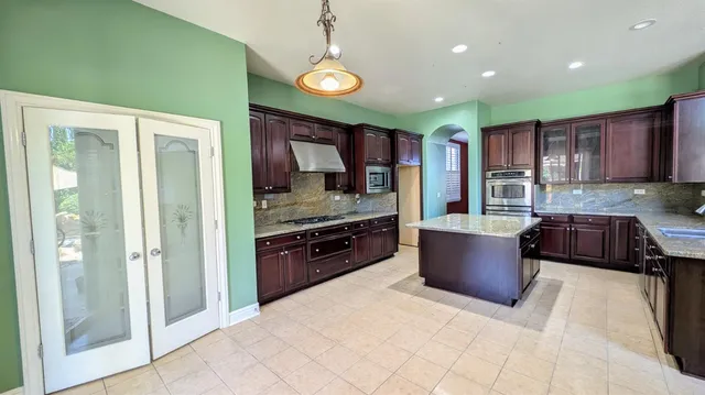 a kitchen with stainless steel appliances granite countertop wooden cabinets a stove top oven a sink and dishwasher