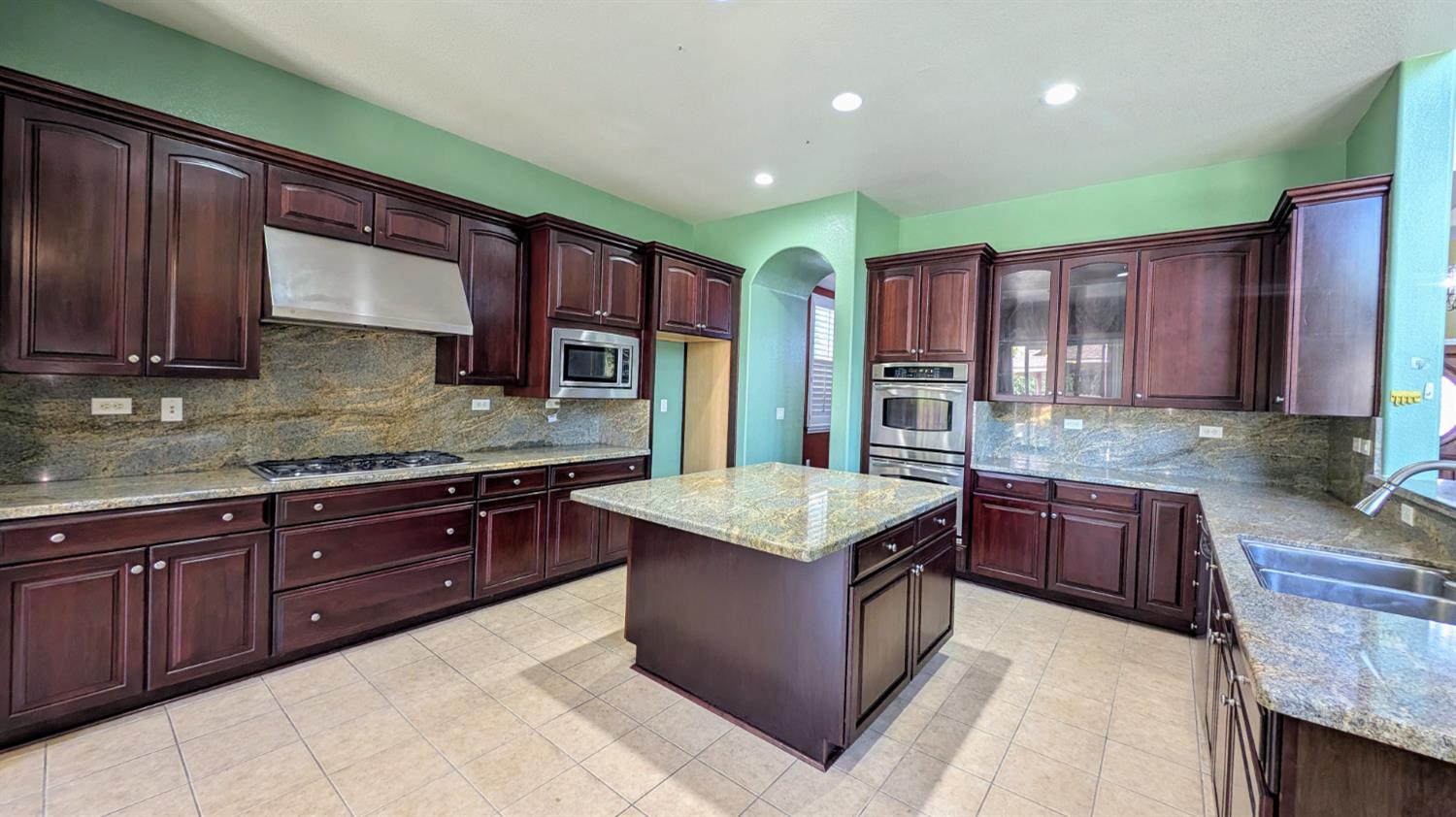 4389 Kilroy Court Rancho Cordova, CA 95742 - Photo 15 of 47 a kitchen with stainless steel appliances granite countertop wooden cabinets a stove top oven a sink and dishwasher