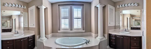 a bathroom with a tub sink and mirror