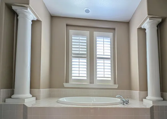 a bathroom with a granite countertop tub sink and mirror