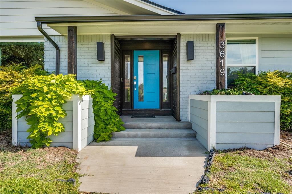 3619 Merrell Road Dallas, TX 75229 - Photo 1 of 26 Inviting entryway featuring a vibrant blue front door, white painted brick, concrete steps, and integrated planters with lush greenery
