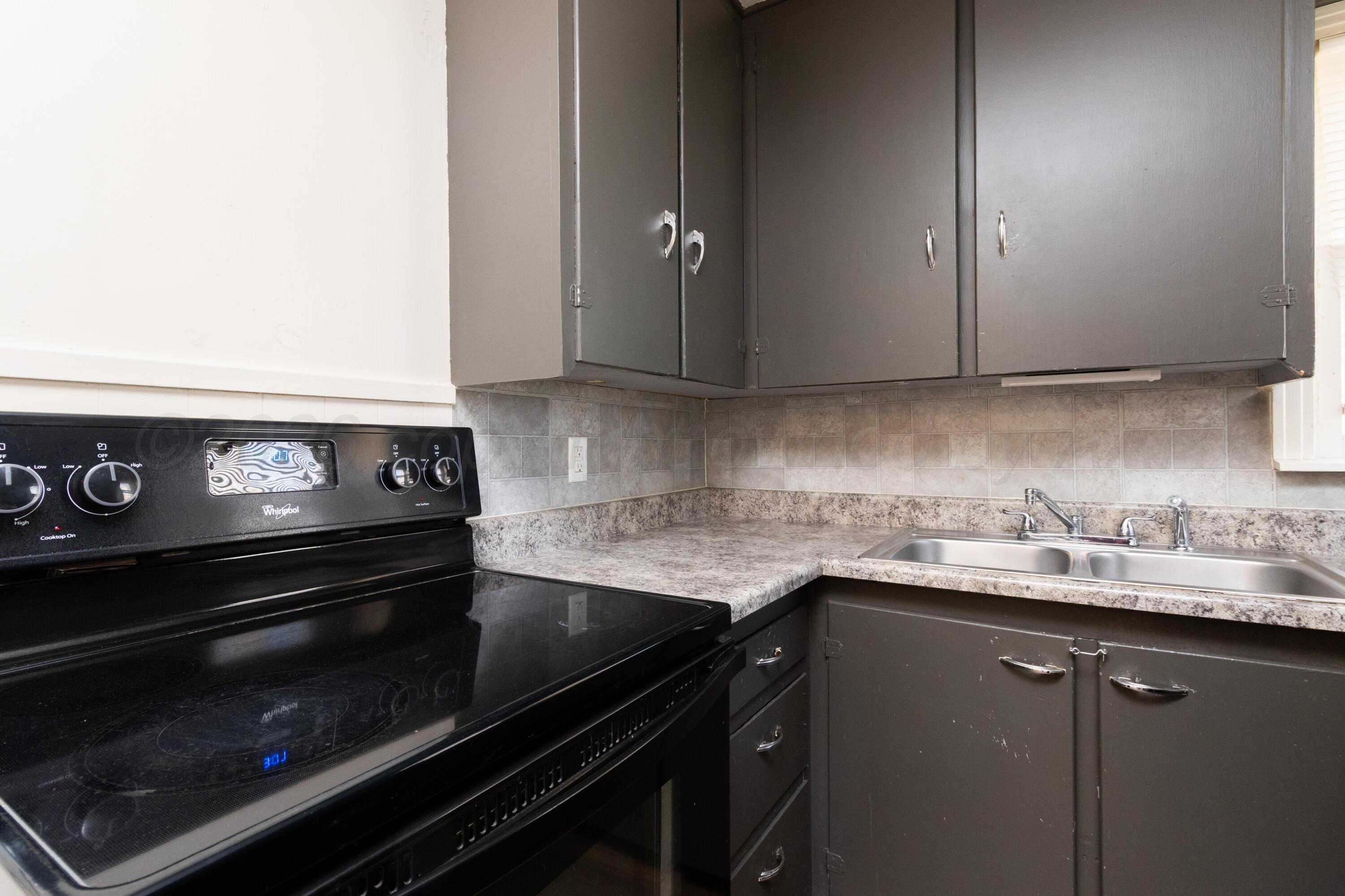 4211 South Travis Street Amarillo, TX 79110 - Photo 11 of 21 a kitchen with a sink stove and cabinets