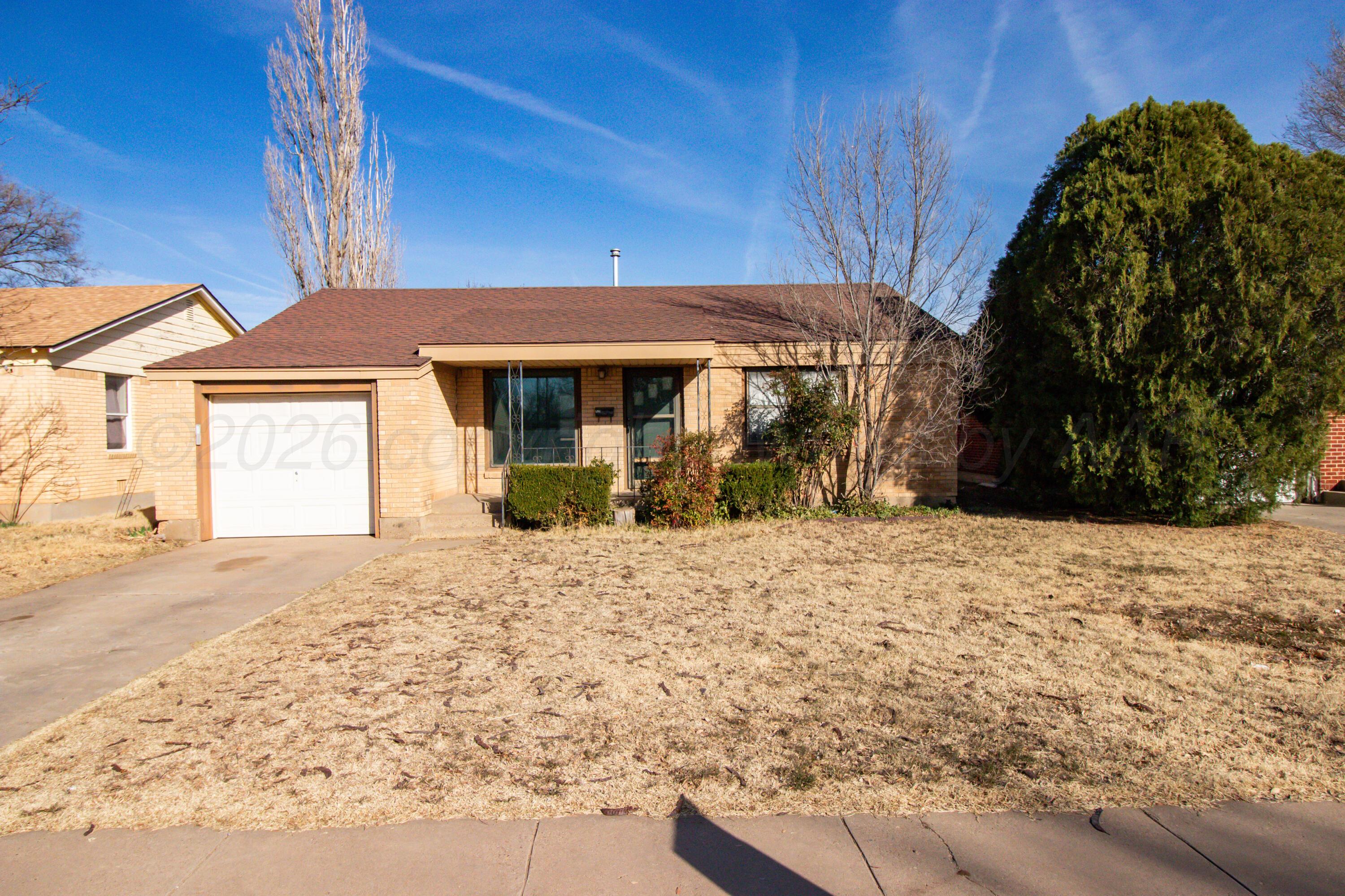 4211 South Travis Street Amarillo, TX 79110 - Photo 2 of 21 a front view of a house with a yard