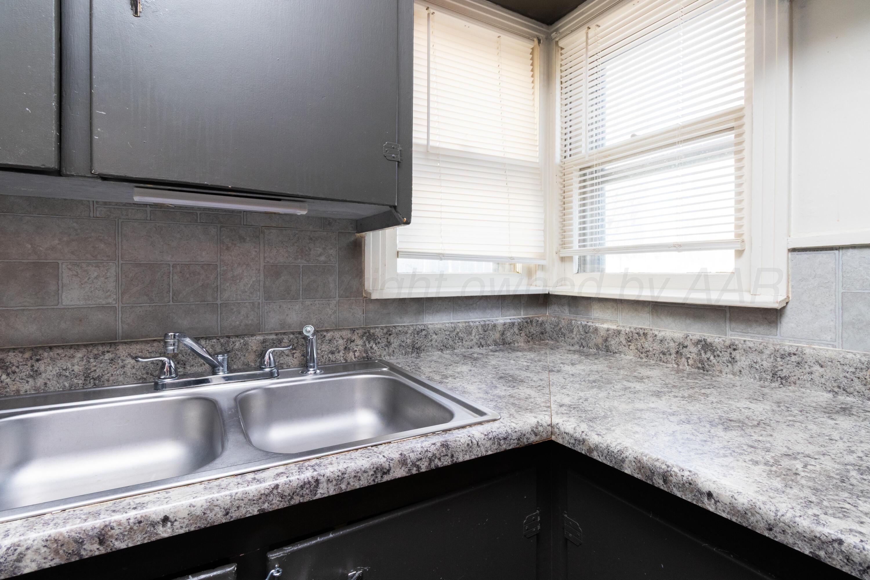 4211 South Travis Street Amarillo, TX 79110 - Photo 10 of 21 a kitchen with a sink and a window