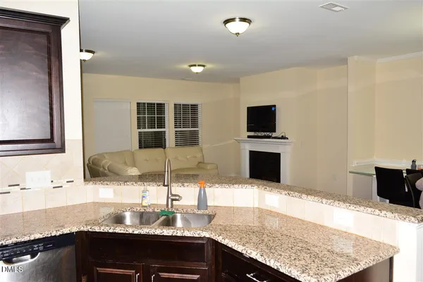 a kitchen with granite countertop a sink and a stove top oven with wooden floor