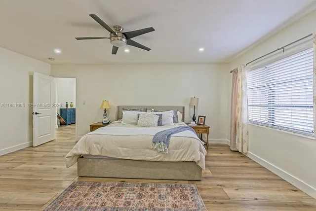 a bedroom with a large bed and a ceiling fan