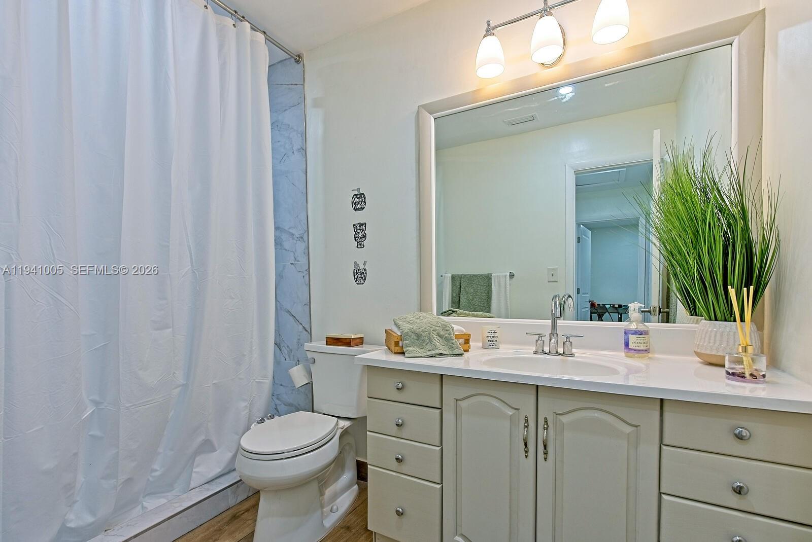10900 Southwest 124th Road Miami, FL 33176 - Photo 18 of 22 a bathroom with a sink a toilet and shower curtain