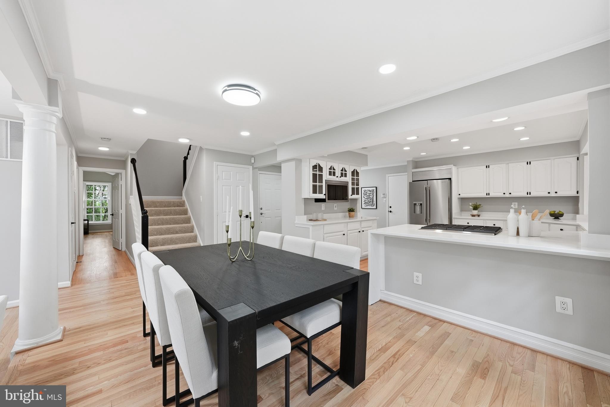 1291 Lamplighter Way Reston, VA 20194 - Photo 25 of 60 a kitchen with stainless steel appliances kitchen island granite countertop a table chairs sink and cabinets