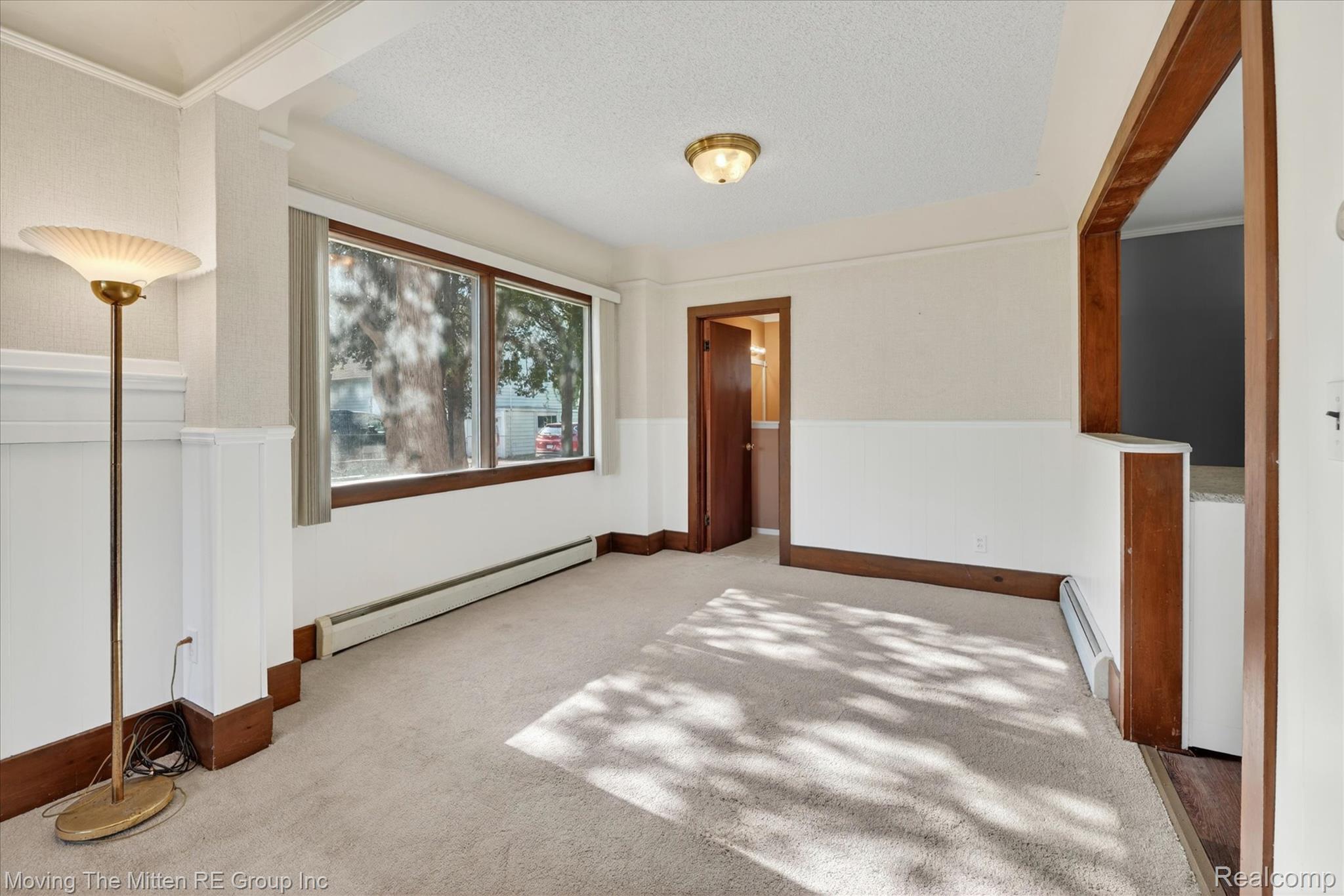 25505 Wick Road Taylor, MI 48180 - Photo 9 of 68 Spare room featuring a wainscoted wall, baseboard heating, light carpet, a textured ceiling, and a baseboard radiator