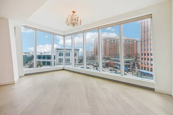 a view of a big room with wooden floor and windows