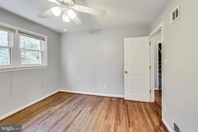 wooden floor in an empty room with a window