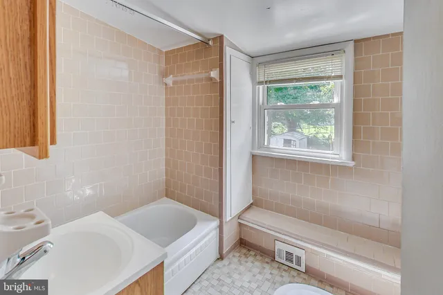 a bathroom with a tub a sink and a toilet