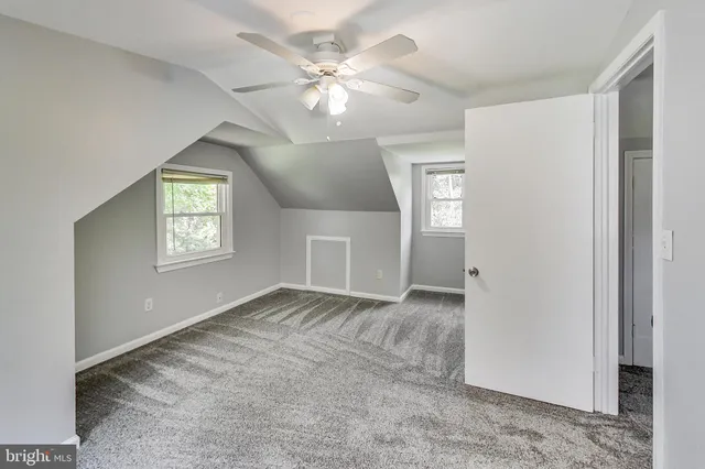 an empty room with windows and ceiling fan