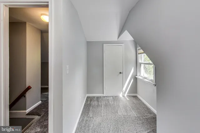 a view of a hallway with wooden floor and entryway