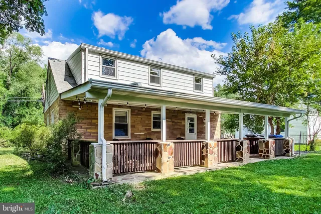 a view of a house with a backyard and a large tree