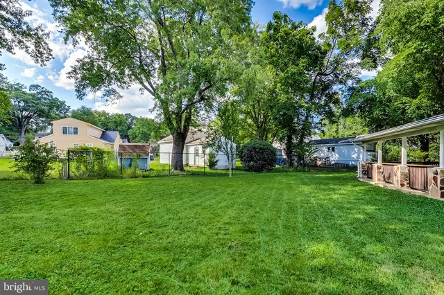 a view of a house with a big yard and large trees