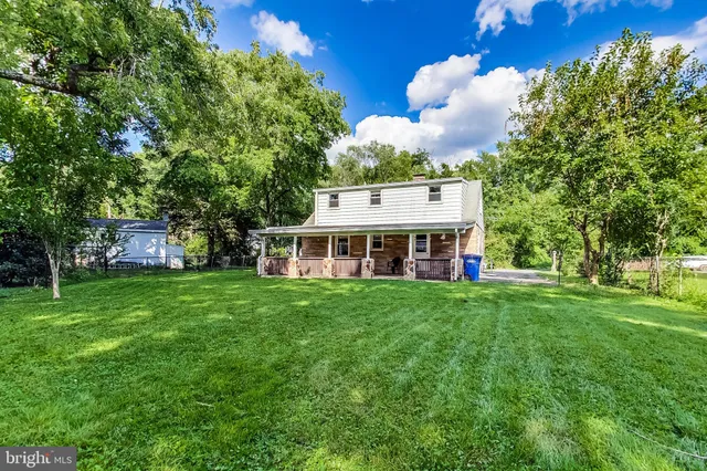 a view of a house with a big yard and large trees