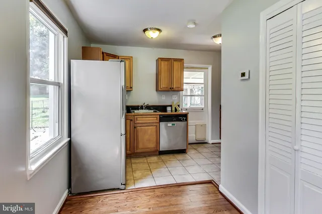 a kitchen with granite countertop a refrigerator and a stove top oven
