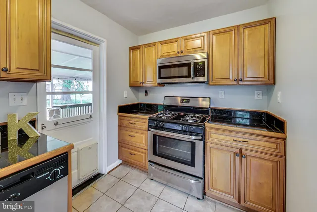 a kitchen with stainless steel appliances granite countertop a stove microwave and sink