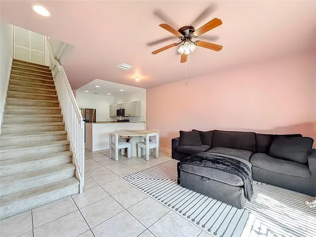 a living room with furniture and a ceiling fan