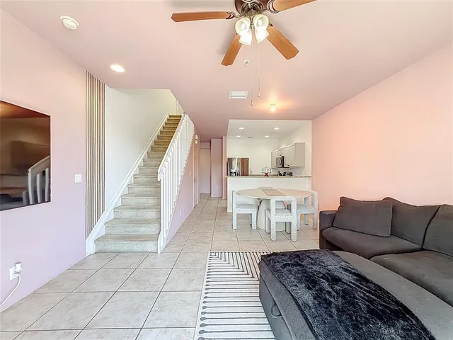 a living room with furniture a flat screen tv and kitchen view