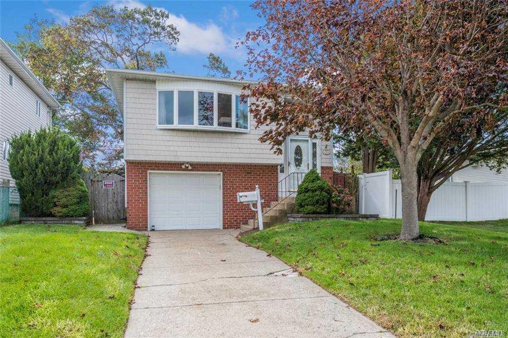 243 Riviera Parkway Lindenhurst, NY 11757 - Photo 1 of 1 a front view of a house with a yard and garage