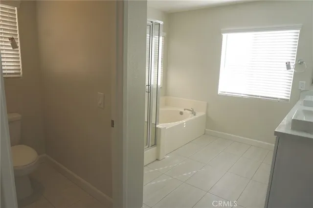 a bathroom with a tub a sink a window and a shower
