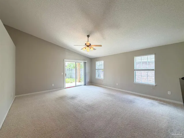 a view of a room with windows and chandelier fan