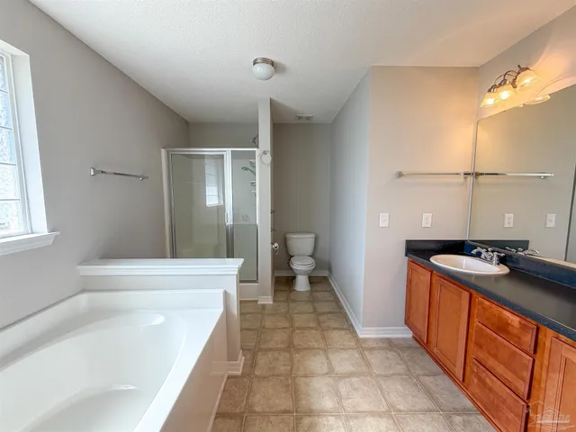 a bathroom with a granite countertop sink a toilet and bathtub
