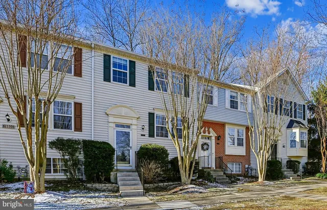 a view of a brick house with many windows next to a road