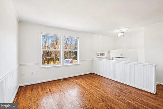 an empty room with a window and wooden floor