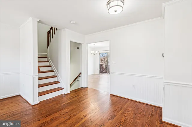 a view of a hallway with wooden floors and stairs