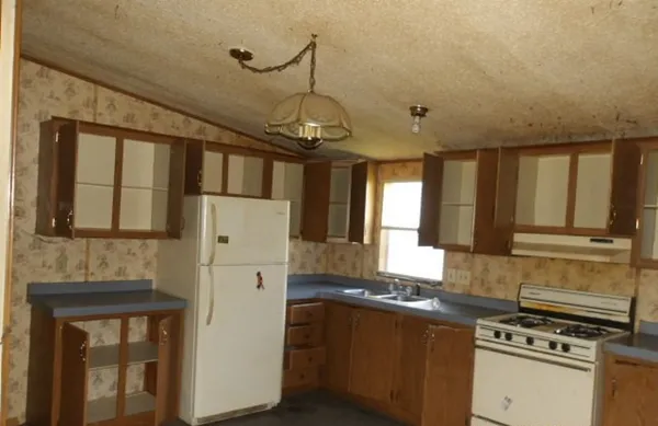 a kitchen with stainless steel appliances granite countertop a refrigerator and a stove