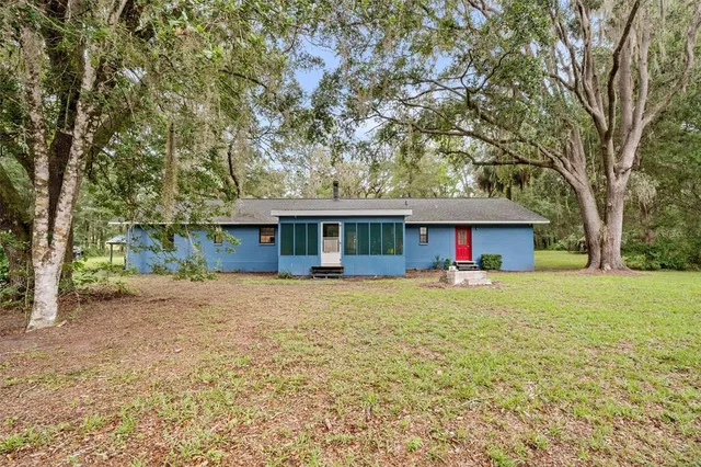 a front view of a house with a yard and trees