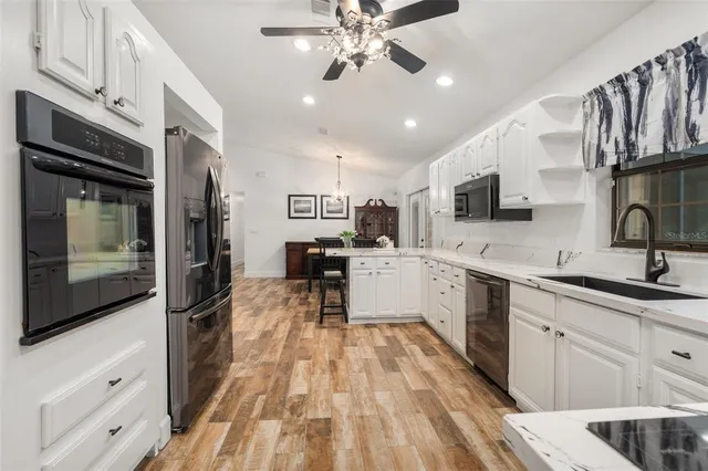 a kitchen with a sink stainless steel appliances and white cabinets