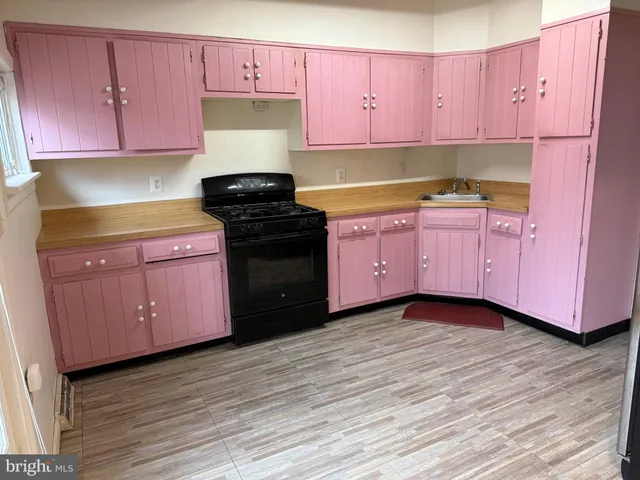 a kitchen with granite countertop wooden cabinets stainless steel appliances and wooden floor