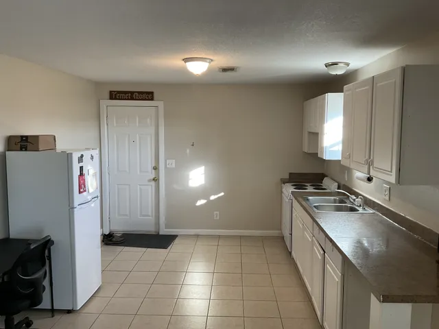 a kitchen with a sink a stove and a refrigerator