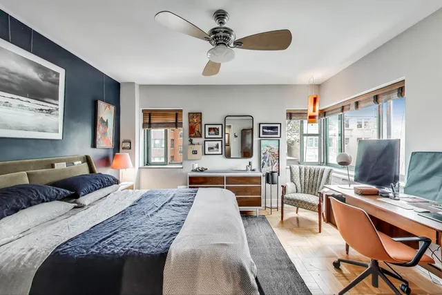 a bedroom with a bed a couch and large window