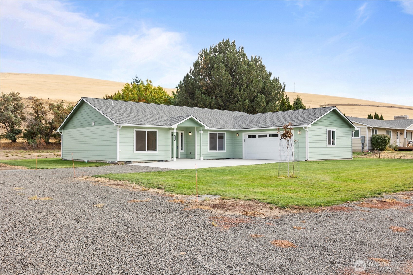 a front view of house with yard and trees in the background