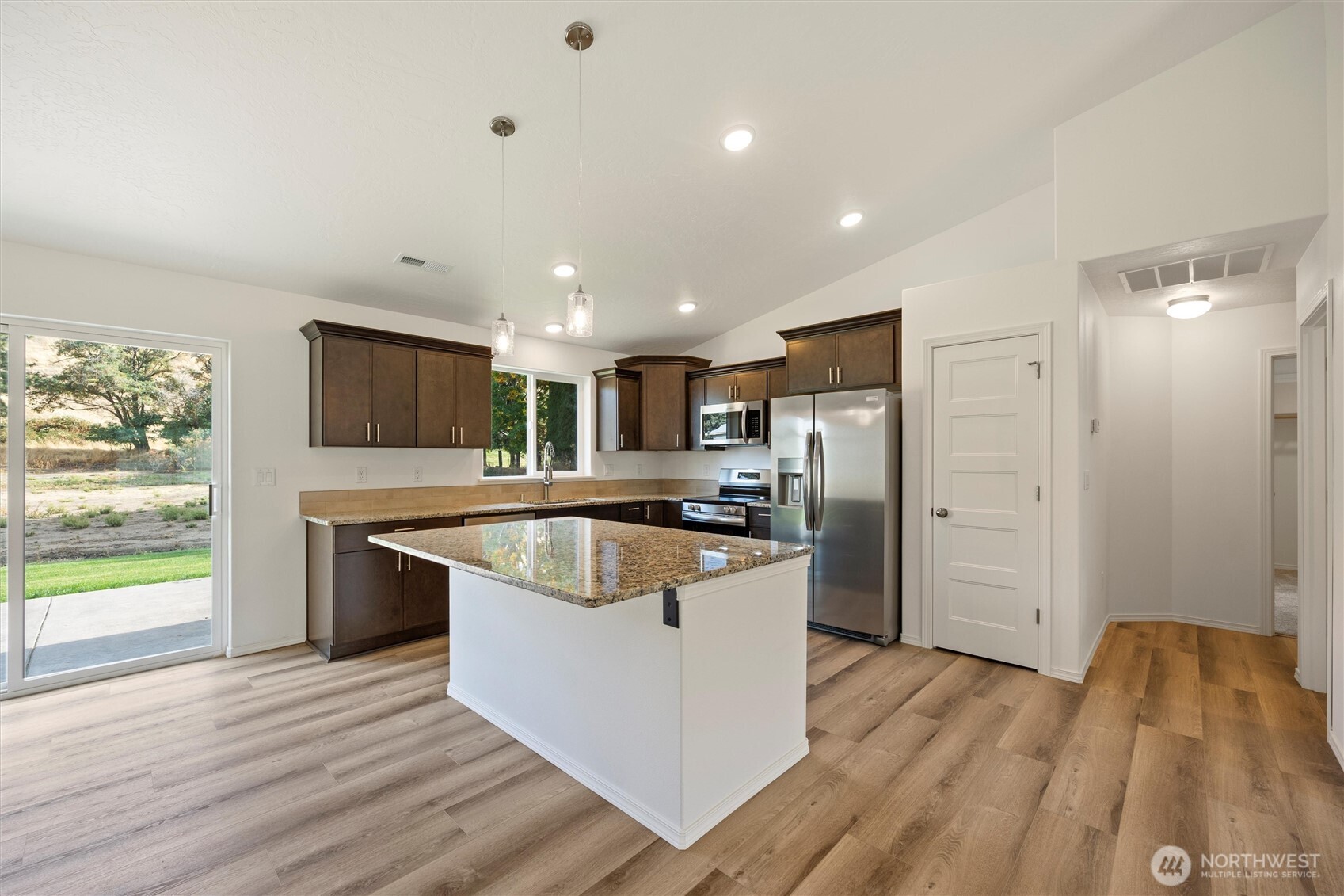 1507 South 5th Street Dayton, WA 99328 - Photo 12 of 35 a kitchen with stainless steel appliances granite countertop a refrigerator a sink dishwasher a stove and white countertops with wooden floor