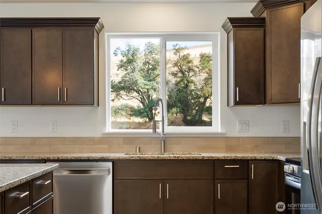a kitchen with granite countertop a sink and a window