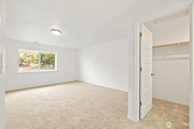 an empty room with windows and closet