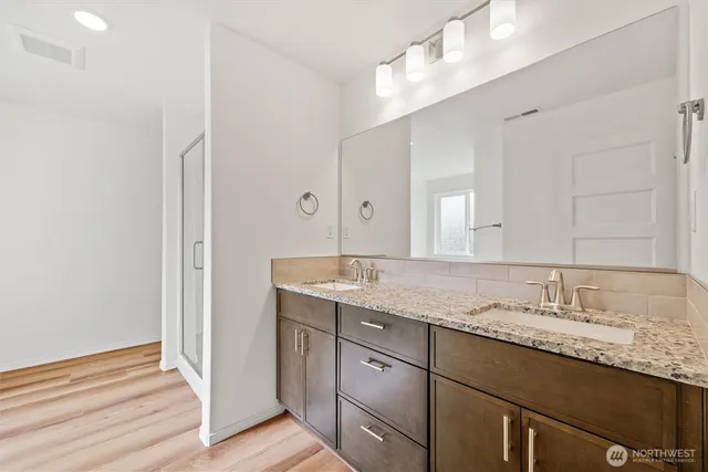 a bathroom with a granite countertop sink and a mirror
