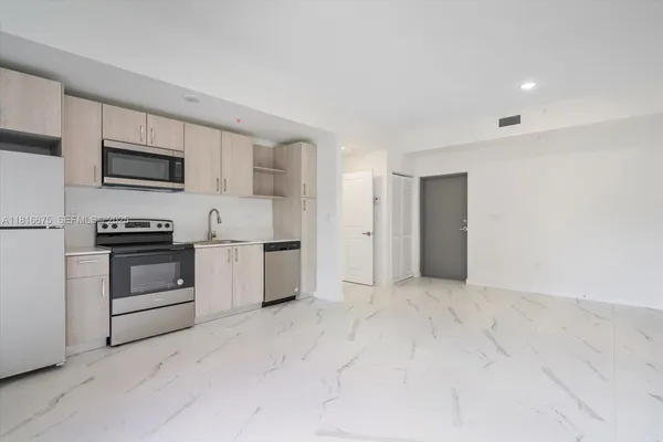 a kitchen with stainless steel appliances a stove a microwave and white cabinets