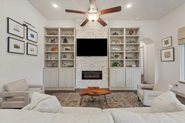 a living room with furniture a fireplace and a flat screen tv