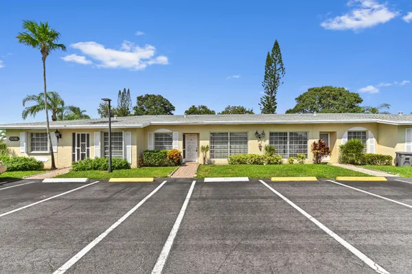a front view of a house with a yard and trees