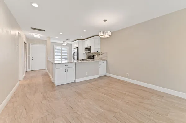 wooden floor in an empty room with a kitchen