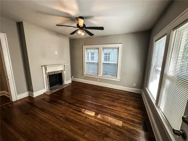 a large kitchen with stainless steel appliances granite countertop a stove a sink dishwasher a refrigerator white cabinets and wooden floor