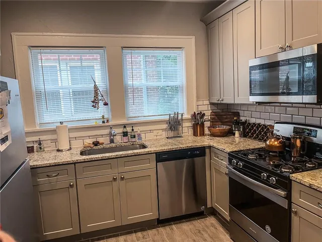 a kitchen with metallic refrigerator freezer and a dishwasher